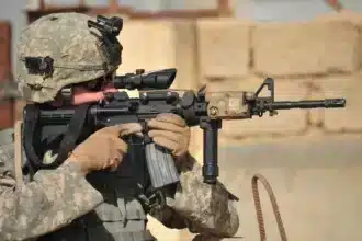 Un spécialiste de l'armée américaine dans la lutte de Kirkouk, prêt avec son arme lors d'une patrouille de sécurité, illustre les défis rencontrés par le gouvernement fédéral irakien dans la protection des droits humains.
