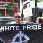 Members of the Alberta-based neo-nazi group Aryan Guard stage a counter-protest, at an anti-racism rally. They are seen here on the Southwest corner of Kensington Road and 10 Street Northwest in Calgary, Alberta, Canada. Photo by Thivierr licensed under CC BY-SA 3.0.
