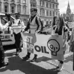 The scenario involves a police officer filming a Just Stop Oil activist on Whitehall near Parliament Square on 20 May 2023. This situation exemplifies the complex dynamics between violence and nonviolence, often dubbed the "Violence-Nonviolence Binary," within the context of social activism and law enforcement.