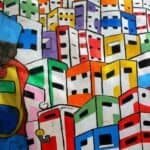 Mur de rue vibrant représentant un bidonville urbain coloré et abstrait, symbolisant les couches complexes et les récits cachés de la précarité urbaine.
