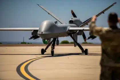 An MQ-9 Reaper drone with missiles on a runway, guided by a camouflaged military operator, illustrating the digital dilemmas of unmanned, AI-equipped warfare technology.