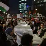Los manifestantes despliegan una lista con los nombres de los más de 12,000 civiles, incluyendo 6,150 niños y 5,000 mujeres, que han sido asesinados por el ejército israelí en Gaza desde el 7 de octubre de 2023. Esta es una protesta contra la violencia sagrada.