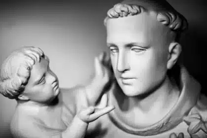 La imagen representa una escultura con claras connotaciones de teología política. Muestra dos figuras, un adulto con una expresión contemplativa y rasgos clásicos, y una figura similar a un niño que parece estar interactuando con el adulto. El cabello detallado del adulto y su vestimenta tradicional sugieren una figura de importancia histórica o religiosa, posiblemente una representación de un santo o filósofo, lo que se alinea con los temas de la teología política. La figura más pequeña, con su apariencia angélica, podría simbolizar la inspiración o influencia divina. Esta composición evoca la exploración de la teología política sobre la interacción entre principios religiosos o divinos y el gobierno secular.