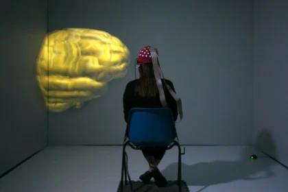 Neuropolitics: a woman sitting in a chair looking at a yellow brain