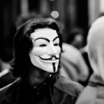 Persona con una máscara de Guy Fawkes, un símbolo popular de la lucha contra la censura, en un entorno urbano. La máscara representa la resistencia contra la opresión y la tiranía de la opinión predominante.