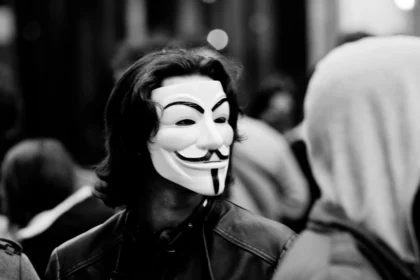 Persona con una máscara de Guy Fawkes, un símbolo popular de la lucha contra la censura, en un entorno urbano. La máscara representa la resistencia contra la opresión y la tiranía de la opinión predominante.