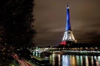 La Torre Eiffel  iluminada tras los atentados de París de noviembre de 2015, simbolizando el luto, la solidaridad y la resiliencia frente al terrorismo. Foto de Yann Caradec.