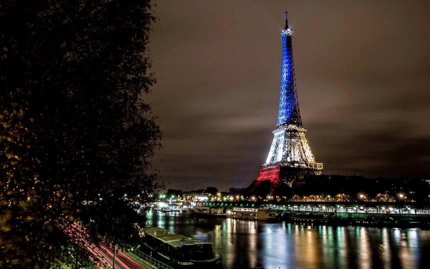 La Torre Eiffel  iluminada tras los atentados de París de noviembre de 2015, simbolizando el luto, la solidaridad y la resiliencia frente al terrorismo. Foto de Yann Caradec.