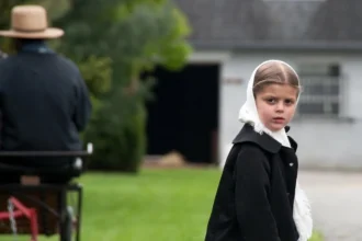 This image captures the striking contrast between the simple, traditional life of an Amish girl and the broader ideals of liberal democracy, emphasizing individual freedom and modernity. Explore how these two worlds coexist and the values they represent.