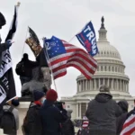 Supporters of Donald Trump gather outside the U.S. Capitol on January 6th, 2021, displaying flags and symbols that emphasize their partisan identity. The scene reflects the intense polarization in U.S. politics, where cognitive closure— the psychological need for certainty and clear identities—drives individuals to align strongly with their chosen political party, leading to heightened hostility and division between opposing groups.