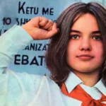 Albanian women: A young girl wearing a white shirt and a red scarf in the style of an Albanian communist pioneer raises her fist in a revolutionary salute. The image, taken from Ylli Magazine, reflects the official ideology of the Albanian communist regime of the time, promoting socialist values and contributing to state propaganda.