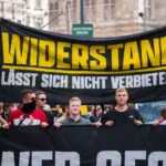 Partidarios del Movimiento Identitario de Austria (Identitäre Bewegung), una organización de extrema derecha, marchan por las calles de Viena portando una pancarta que dice «La resistencia no puede ser prohibida». El movimiento forma parte de una red más amplia de la derecha radical en toda Europa, que aboga por políticas nacionalistas y antiinmigración. Sus manifestaciones, como la que se muestra aquí, tienen como objetivo resistir lo que perciben como amenazas a la identidad europea debido a la globalización y la inmigración. Estas acciones han generado una importante controversia y críticas, ya que muchos consideran que la retórica del grupo promueve la división y la xenofobia.