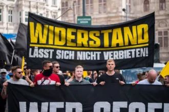 Supporters of Austria's Identitarian Movement (Identitäre Bewegung), a far-right organization, march through the streets of Vienna carrying a banner that reads "Resistance cannot be banned." The movement is part of the broader radical right network across Europe, advocating for nationalist and anti-immigration policies. Their demonstrations, like the one shown here, aim to resist what they perceive as threats to European identity due to globalization and immigration. These actions have sparked significant controversy and criticism, with many viewing the group’s rhetoric as promoting division and xenophobia.