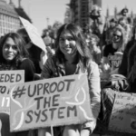Climate rights protest with young activists holding signs advocating for system change and environmental justice.