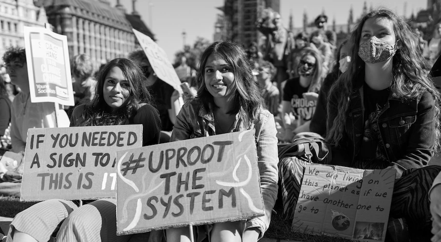 Protesta por los derechos climáticos con jóvenes activistas sosteniendo carteles que abogan por un cambio de sistema y justicia ambiental.