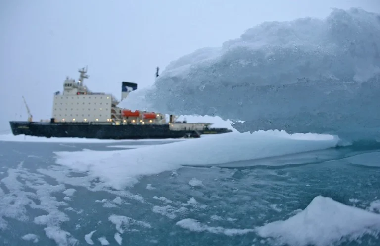 A research vessel cuts through the icy Arctic waters, viewed through a clear lens of ice, highlighting the extreme conditions faced during polar expeditions.