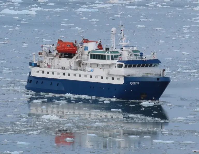 The vessel 'Quest' navigates through icy waters in the Arctic, surrounded by floating ice.