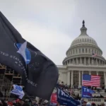 Seguidores de Donald Trump se reúnen frente al Capitolio de los Estados Unidos durante la insurrección del 6 de enero, ondeando banderas estadounidenses y de la campaña de Trump junto con una bandera de la Fuerza Espacial de los Estados Unidos, reflejando un momento vinculado a la visión disputada sobre el futuro de los Estados Unidos bajo la influencia de Trump.