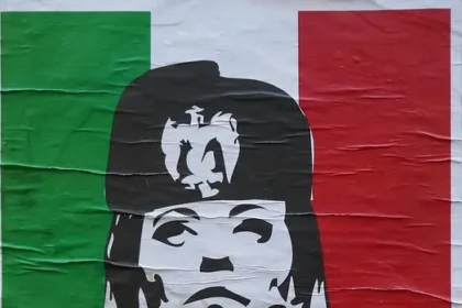 Street poster in Italy depicting Giorgia Meloni with controversial historical references to Benito Mussolini.