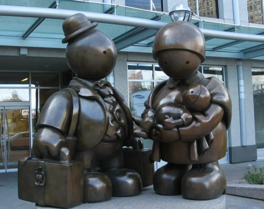 A bronze sculpture titled 'Immigrant Family' by Tom Otterness, symbolizing the challenges and journeys of immigrant families, placed outside a public building to inspire reflection on immigration policies.