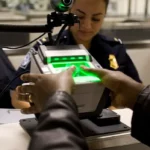 Politicizing the Digital World: Biometric fingerprint scanning at a government checkpoint, illustrating the impact of digitalization on public administration and citizens' rights.