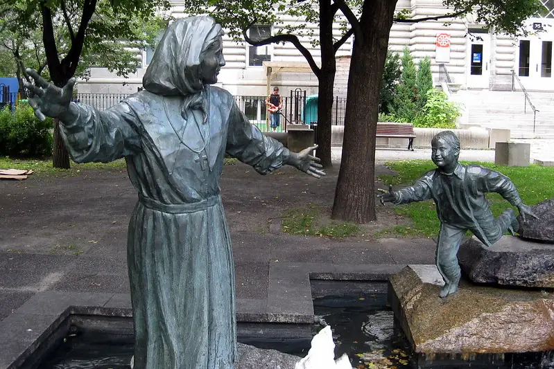 Hommage à Marguerite Bourgeoys, by Jules Lasalle, depicts one of the most influential women in early Canadian history, a pioneering educator and founder of the Congregation of Notre Dame, reaching out to a child. The statue symbolizes her lifelong dedication to teaching and care. It was dedicated on June 29, 1988, in Place Marguerite Bourgeoys, Montreal.