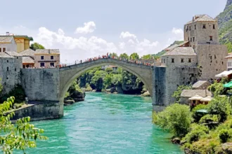 Le Vieux Pont de Mostar reconstruit, initialement édifié au XVIᵉ siècle, a été détruit pendant la guerre de Bosnie en 1993 et reconstruit en 2004 comme symbole de réconciliation et de préservation du patrimoine culturel. Photo de Dennis G. Jarvis (CC BY-SA).