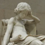 Cette sculpture en marbre représente un jeune Aristote en profonde contemplation, symbolisant le développement précoce du jugement moral et de la quête philosophique.