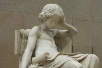Esta escultura de mármol representa a un joven Aristóteles en profunda contemplación, simbolizando el desarrollo temprano del juicio moral y la indagación filosófica.