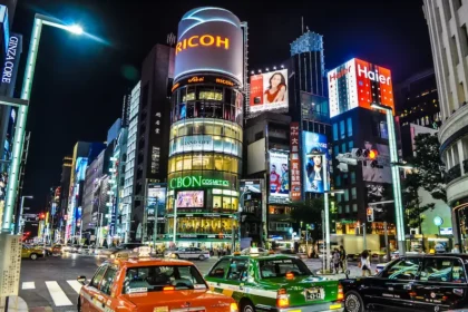 Contemporary view of Ginza, Tokyo. The illuminated spectacle of branded signage reflects the long-term influence of Commercial Art on Japan’s urban consumer spaces.