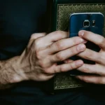 Holding faith and code: a visual metaphor of technology's rise as a modern belief system.