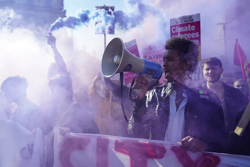 An anti-racism activist addresses the crowd during a demonstration in London. Protest functions as a vital democratic practice when institutional mechanisms fail to respond.Photo by Alisdare Hickson (CC BY-SA).