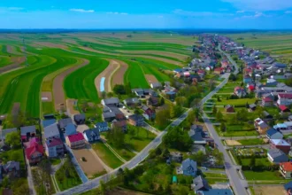 Vista aérea de un pueblo y sus campos circundantes. La organización de la tierra sigue moldeando el poder y la desigualdad en las sociedades modernas. Foto de Florian Vataj.