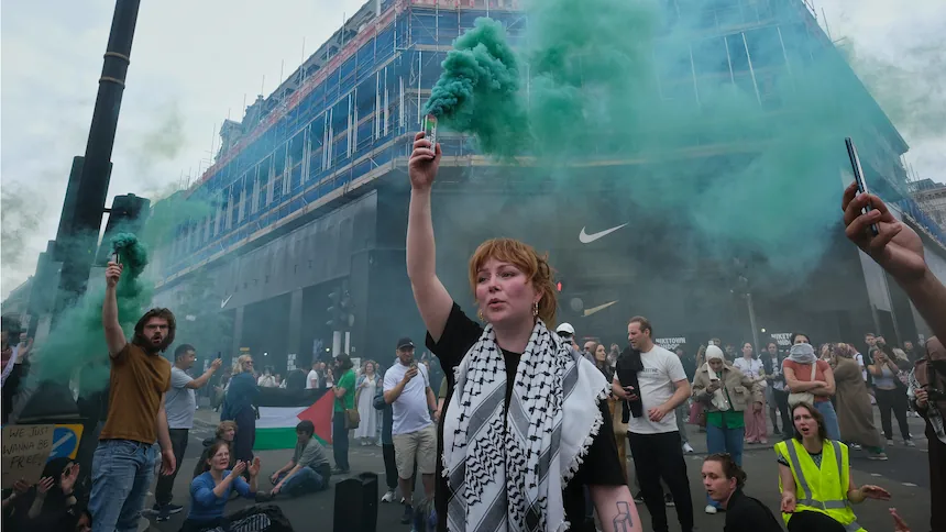 Des manifestants expriment leur solidarité avec Gaza en utilisant des actes visuels et performatifs pour revendiquer une visibilité politique et contester les récits dominants. Cette action collective illustre l’usage de la voix au-delà des institutions démocratiques formelles. Photo par Alisdare Hickson (CC BY-SA).