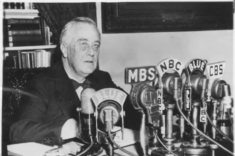 Franklin D. Roosevelt dando una charla junto a la chimenea, ilustrando el contraste entre la comunicación política en formato extenso y la política actual de atención fugaz.
