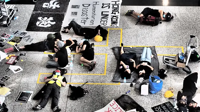 Pro-democracy protesters in Hong Kong lie on the ground beside banners denouncing Beijing’s repression and calling attention to a growing humanitarian crisis.
