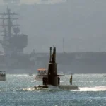 A Swedish Gotland-class diesel-electric submarine in front of a U.S. aircraft carrier — a real-world example of stealth, efficiency, and strategic surprise that inspires the proposed “Hickel Class” fleet.