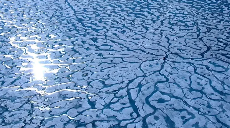 Aerial view of fragmented Arctic sea ice shaped by shifting currents and seasonal melt patterns in the polar North. Photo by Mike Beauregard CC BY).