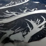 Aerial view of a braided gravel outwash plain formed by glacial meltwater on the northeast coast of Baffin Island, Nunavut, in the Canadian Arctic. Photo by Mike Beauregard CC BY).