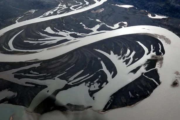 Aerial view of a braided gravel outwash plain formed by glacial meltwater on the northeast coast of Baffin Island, Nunavut, in the Canadian Arctic. Photo by Mike Beauregard CC BY).