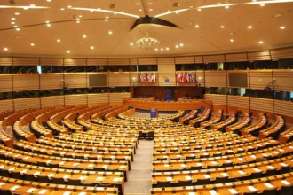 Economization of Politics : The European Parliament Institutional design shaped by Maastricht's economic logic, constraining EU responses to geopolitical crises. Photo by Ash Crow (CC BY-SA)