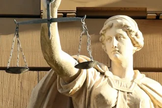 A statue of Justitia holding her traditional scales captures the balancing role now expected of constitutional courts as they adjudicate the fairness of elections. Public Domain.