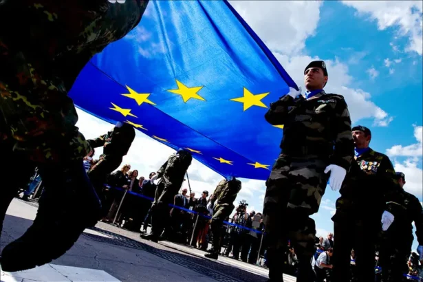 Des soldats portent le drapeau européen lors d'une cérémonie militaire, une image appropriée pour un continent qui débat de la mesure dans laquelle son économie de guerre devrait remodeler les symboles et les structures de l'intégration. Photo du Parlement européen (CC BY-NC-ND)