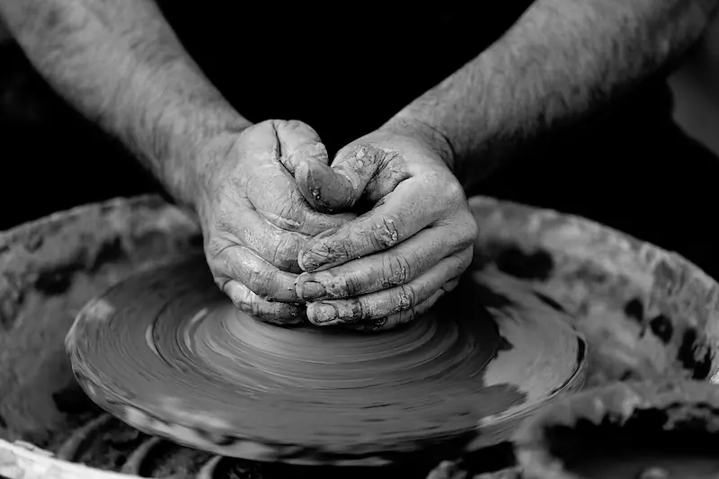 A potter's hands shaping clay on the wheel: the kind of embodied, uncodifiable skill that lies at the heart of tacit knowledge.