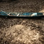 Worlds end : A boat left stranded on cracked earth, its water gone. A small, literal picture of what it means when a world ends. Photo by Pijarn Jangsawang, public domain.